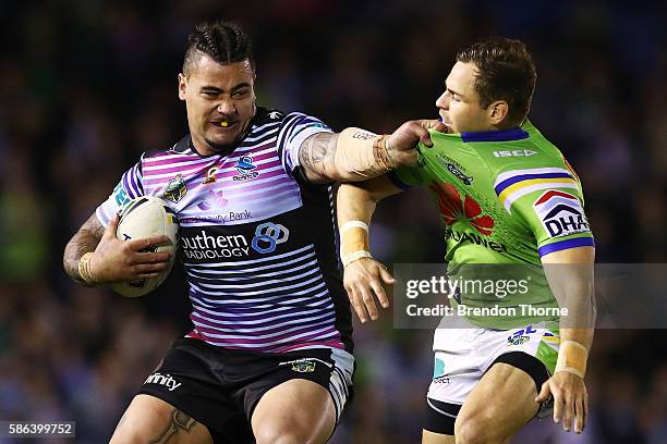 Andrew Fifita of the Sharks fends off Aidan Sezer of the Raiders during the round 22 NRL match between the Cronulla Sharks and the Canberra Raiders...