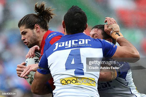 Jake Mamo of the Knights is tackled by the Bulldogs defence during the round 22 NRL match between the Newcastle Knights and the Canterbury Bulldogs...