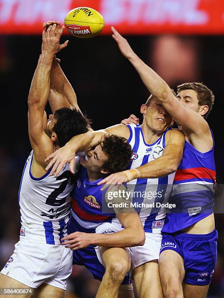 Robbie Tarrant of the Kangaroos and Drew Petrie compete for the ball against Zaine Cordy and Fletcher Roberts of the Bulldogs during the round 20 AFL...