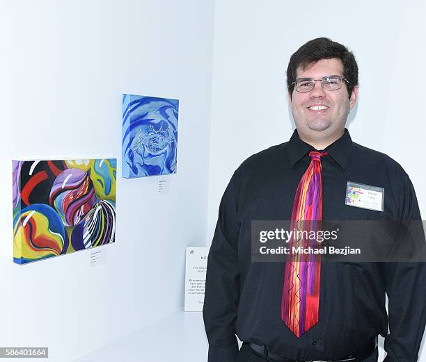 Artist Brandon Newcomer poses with artwork at Artists For Trauma Adaptive Artist Multi-Media Group Art Show on August 5, 2016 in Redondo Beach,...