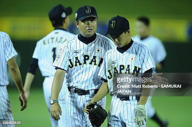 Manabu Ishizaki of Japan speaks with Yumeto Taguchi of Japan in the top half of the sixth inning in the super round game between Japan and Panama...