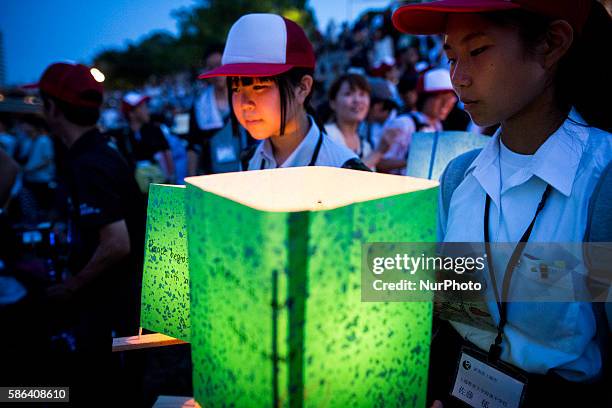 Student wait to float candle lit lanterns with message on the Motoyasu River during the 71st anniversary activities, commemorating the atomic bombing...