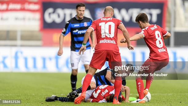 Carsten Kammlott of RW Erfurt and Daniel Brueckner of RW Erfurt challenge Sebastian Schachten of FSV Frankfurt during the Third League match between...