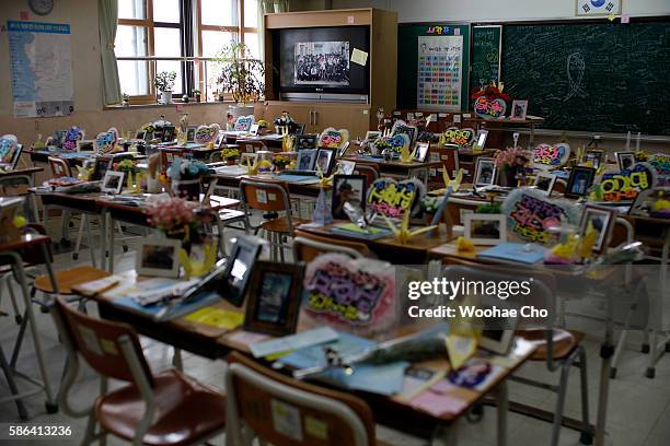 Flowers and notes from colleagues paying tribute to the victims of the Sewol ferry are on the desks in a second year classroom at Danwon High School...