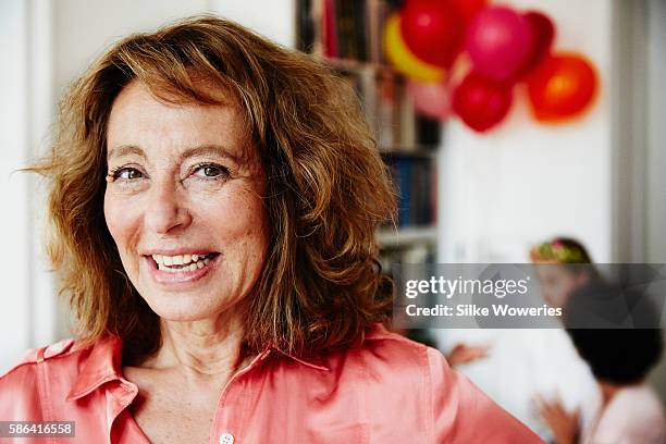 portrait of a content senior adult woman at a birthday party - 60 woman stockfoto's en -beelden