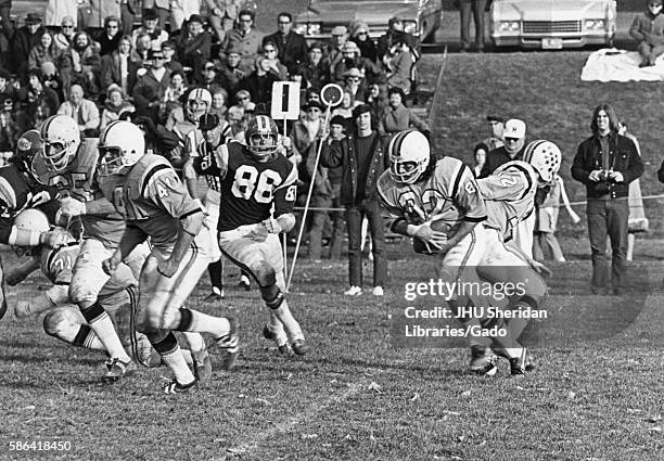 Spectators in the background watch a college football game between Johns Hopkins and Western Montana, October, 1972. .