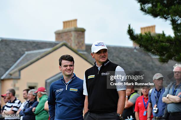 Paul Lawrie of Scotland watches the game of Oliver Fisher and Anthony Wall approach hole 18 on day three of the Aberdeen Asset Management Paul Lawrie...