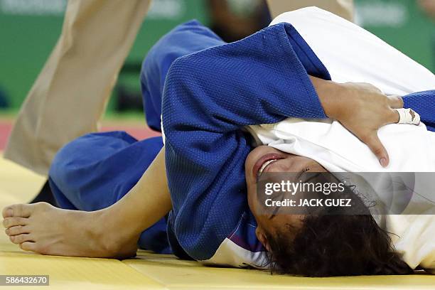 Mongolia's Urantsetseg Munkhbat competes with Brazil's Sarah Menezes during their women's -48kg judo contest repechage match of the Rio 2016 Olympic...