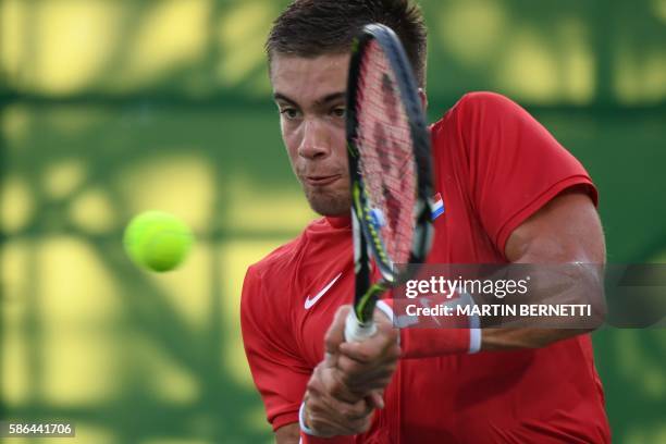 Croatia's Borna Coric returns the ball to France's Gilles Simon during their men's first round singles tennis match at the Olympic Tennis Centre of...