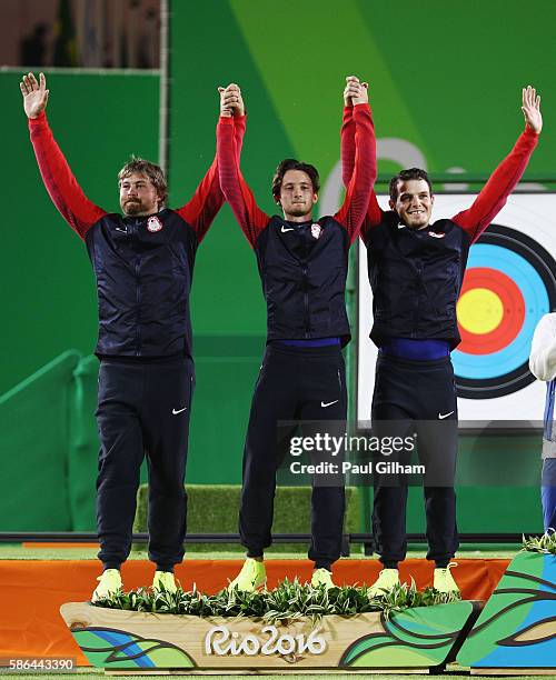 Brady Ellison, Zach Garrett and Jake Kaminski of the United States celebrate with their Silver Medals after finishing second during the Men's Team...