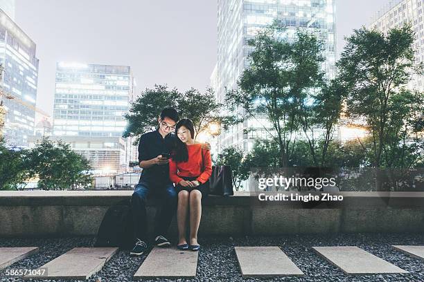 couple using cell phone at night - linghe zhao stock pictures, royalty-free photos & images