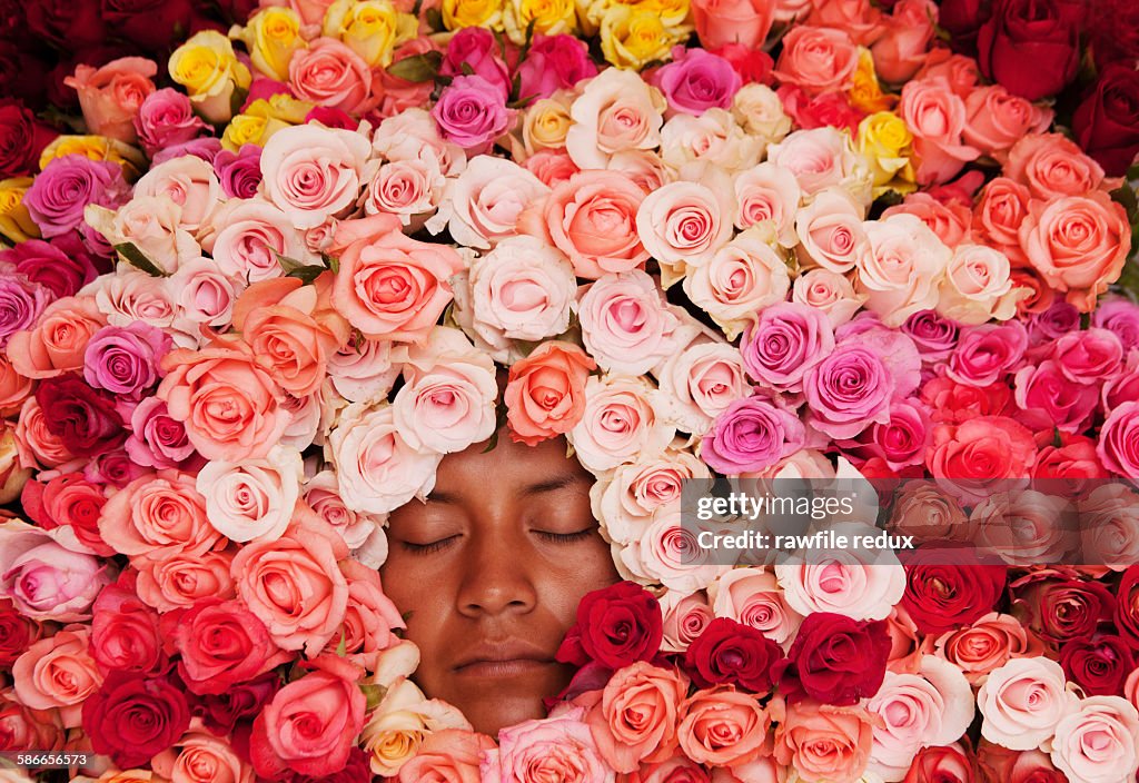 A young woman surrounded by roses