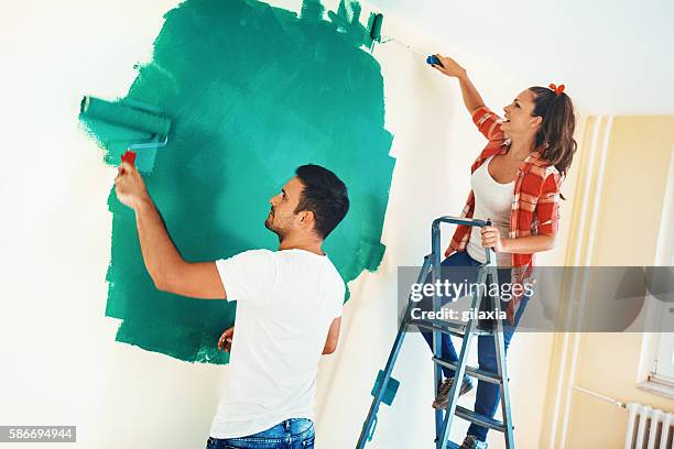 couple painting walls. - painted ceiling stock pictures, royalty-free photos & images