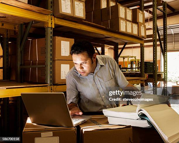 hispanic manager in warehouse - mid adult men stock pictures, royalty-free photos & images