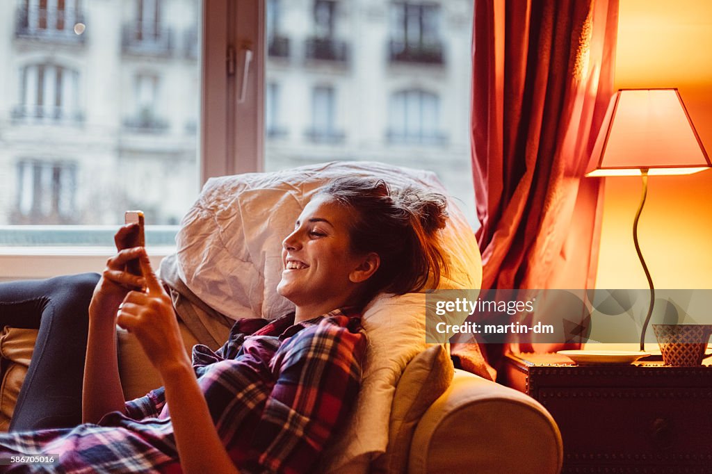 Woman at home texting on phone