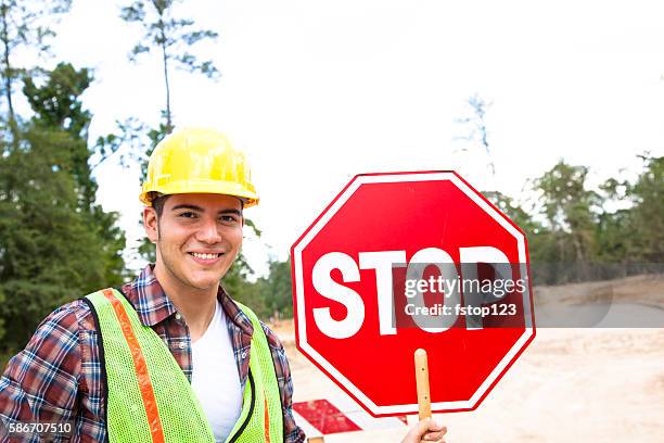 construction worker, signalman holds stop sign at job site. - verkeerspolitie stockfoto's en -beelden