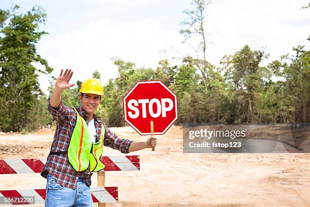 bauarbeiter, signalmann hält stoppschild auf der baustelle. - stop sign stock-fotos und bilder
