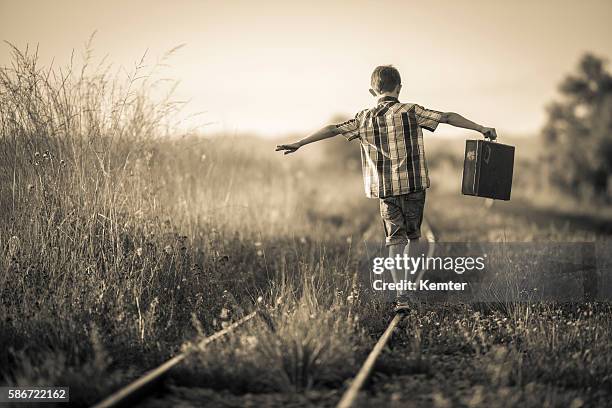 boy with bag balancing on rails - child boy arms out stock pictures, royalty-free photos & images