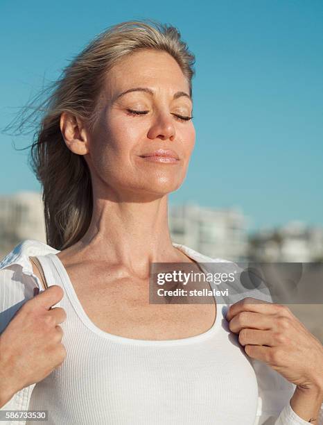 woman inhaling fresh air at the beach - deep breathing stock pictures, royalty-free photos & images