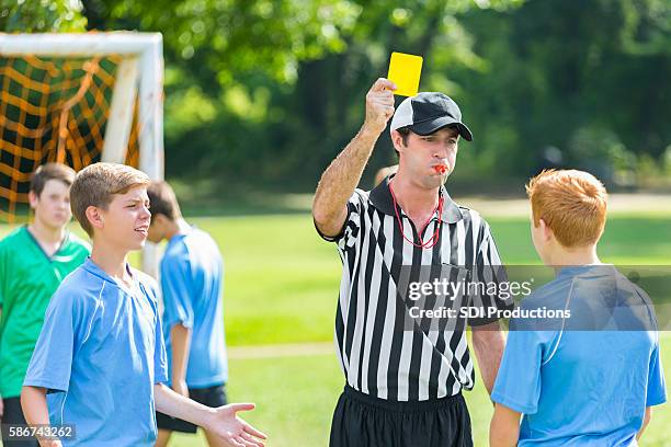 árbitro dá cartão amarelo durante jogo de futebol - foul sports - fotografias e filmes do acervo