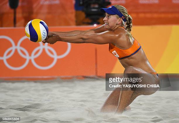 Marleen van Iersel of the Netherlands tries to control the ball during the women's beach volleyball qualifying match between the Netherlands and...