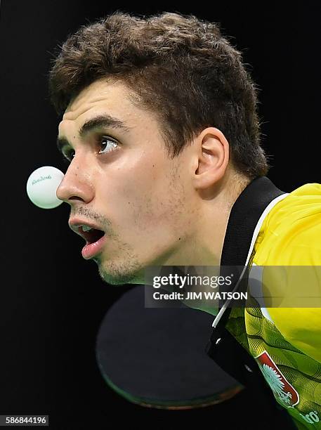 Poland's Jakub Dyjas eyes the ball in his men's singles qualification round table tennis match at the Riocentro venue during the Rio 2016 Olympic...