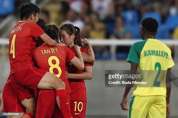 Yasha Gu of China is swarmed by her teammates after scoring China's first goal while Lebohang Ramalepe of South Africa looks on during the Women's...