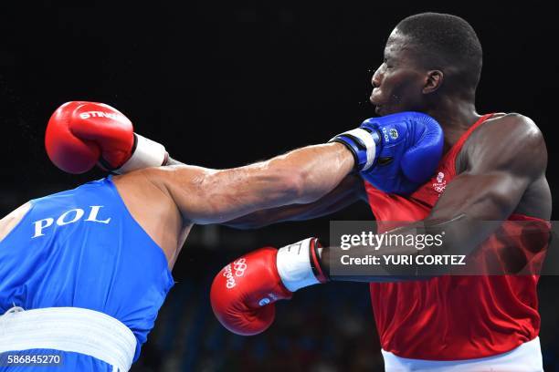 Poland's Igor Pawel Jakubowski lands a punch on Great Britain's Lawrence Okolie during the Men's Heavy match at the Rio 2016 Olympic Games at the...