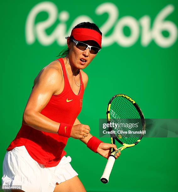 Saisai Zheng of China celebrates a point against Agnieszka Radwanska of Poland in their first round match on Day 1 of the Rio 2016 Olympic Games at...