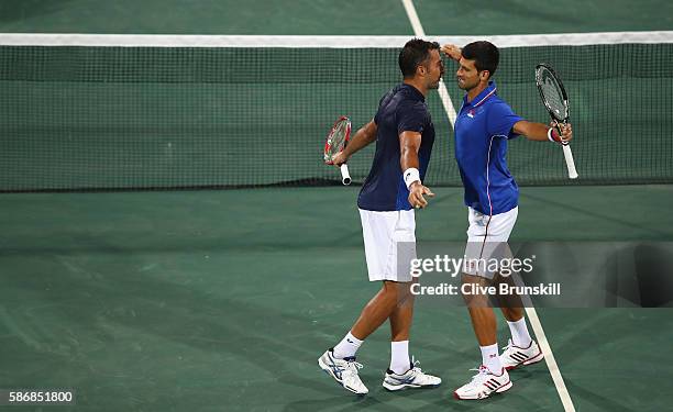 Novak Djokovic and Nenad Zimonjic of Serbia celebrate match point against Marin Ciilic and Marin Draganja of Croatia in their doubles first round...