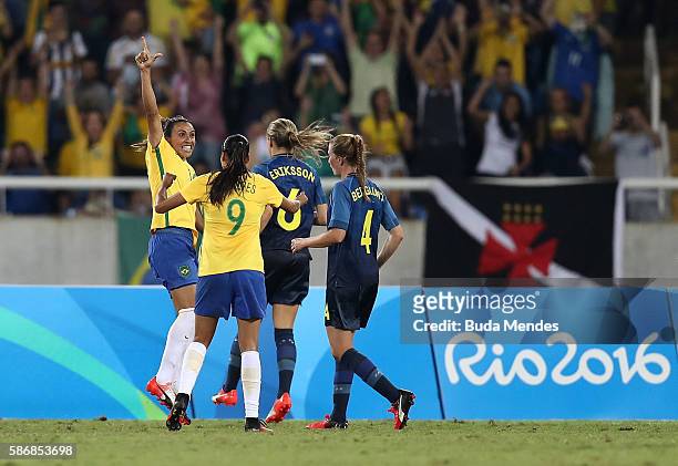 Marta of Brazil celebrates with teammate Andressa Alves after scoring Brazil's third goal during the Women's Group E first round match between Brazil...