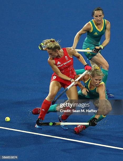 Susannah Townsend of Great Britain collides with Jodie Kenny and Madonna Blyth of Australia during a Women's Pool B match between Australia and Great...