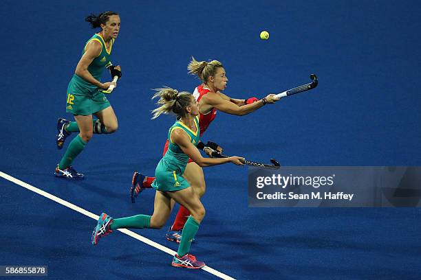 Gabi Nance and Madonna Blyth of Australia chase Susannah Townsend of Great Britain during a Women's Pool B match between Australia and Great Britain...