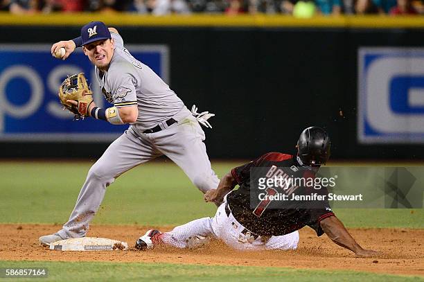 Scooter Gennett of the Milwaukee Brewers makes the force out on Michael Bourn of the Arizona Diamondbacks during the sixth inning at Chase Field on...