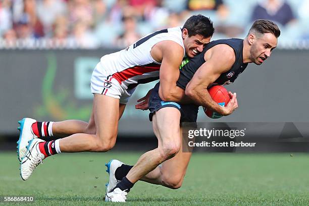 Andrew Walker of the Blues is tackled by Darren Minchington of the Saints during the round 20 AFL match between the Carlton Blues and the St Kilda...