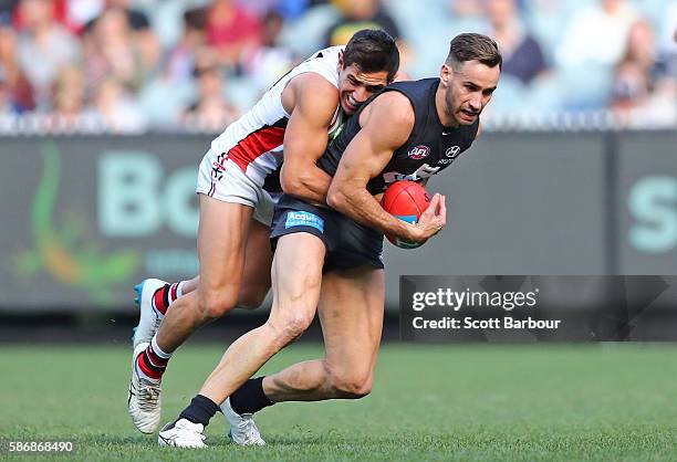 Andrew Walker of the Blues is tackled by Darren Minchington of the Saints during the round 20 AFL match between the Carlton Blues and the St Kilda...