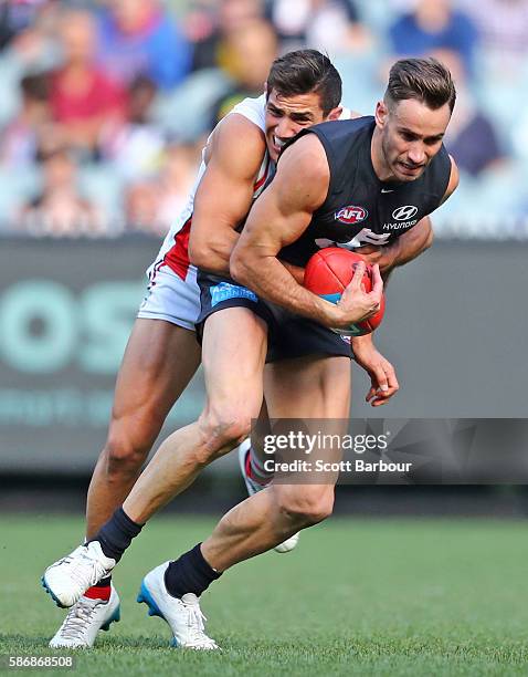 Andrew Walker of the Blues is tackled by Darren Minchington of the Saints during the round 20 AFL match between the Carlton Blues and the St Kilda...