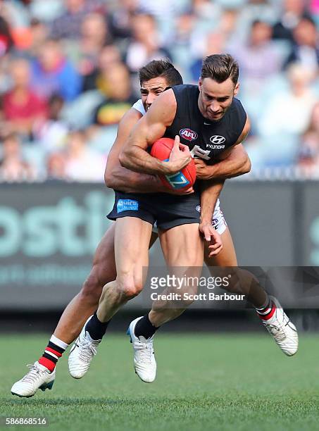 Andrew Walker of the Blues is tackled by Darren Minchington of the Saints during the round 20 AFL match between the Carlton Blues and the St Kilda...