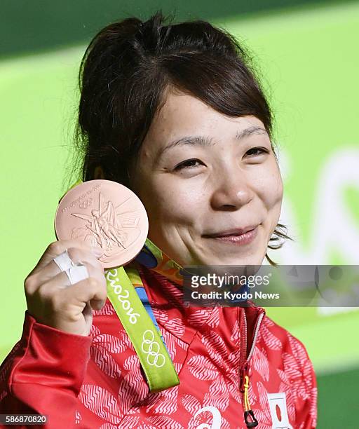 Japanese weightlifter Hiromi Miyake poses with her bronze medal after lifting a total of 188 kilograms in the women's 48-kilogram event at the Rio de...