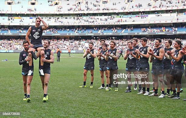 Andrew Walker of the Blues is chaired from the field by Kade Simpson of the Blues and Bryce Gibbs of the Blues as he leaves the field after playing...