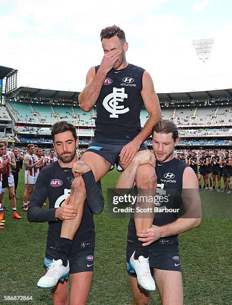 Andrew Walker of the Blues is chaired from the field by Kade Simpson of the Blues and Bryce Gibbs of the Blues as he leaves the field after playing...