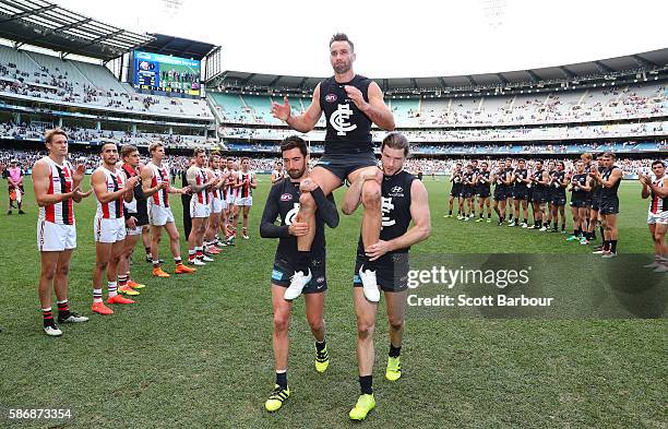 Andrew Walker of the Blues is chaired from the field by Kade Simpson of the Blues and Bryce Gibbs of the Blues as he leaves the field after playing...