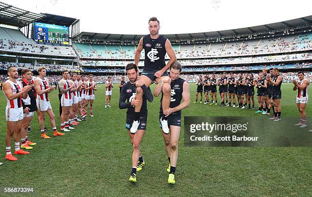 Andrew Walker of the Blues is chaired from the field by Kade Simpson of the Blues and Bryce Gibbs of the Blues as he leaves the field after playing...