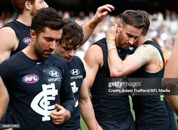 Andrew Walker of the Blues is hugged by teammates after his final game during the 2016 AFL Round 20 match between the Carlton Blues and the St Kilda...
