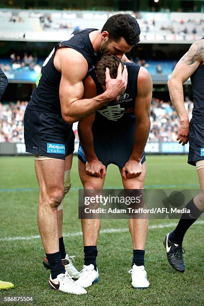 Andrew Walker of the Blues playing his final game is hugged by teammate Simon White of the Blues after the 2016 AFL Round 20 match between the...