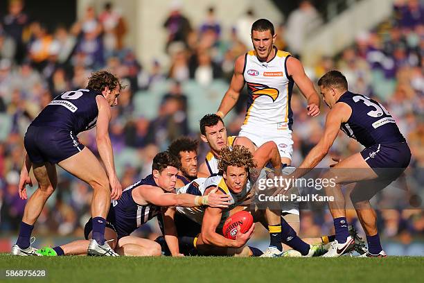 Matt Priddis of the Eagles looks to handball while being tackled by Lachie Neale and Zac Clarke of the Dockers during the round 20 AFL match between...