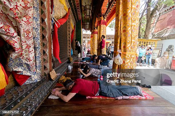 Lama Monks and tourists prostrate themselves in front of the main hall. Kumbum Monastery is one of the two most important Tibetan Buddhist...