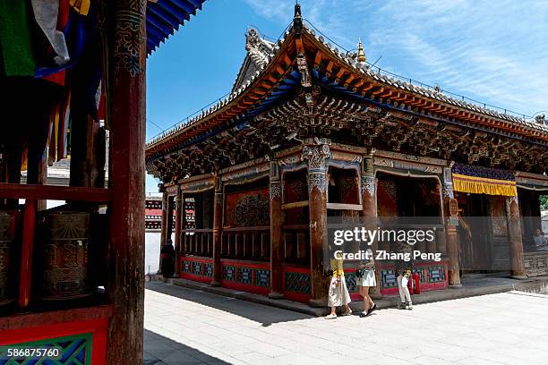 Tourists turn prayer wheels in Ta'er Monastery. Kumbum Monastery is one of the two most important Tibetan Buddhist monasteries outside Tibet. In...