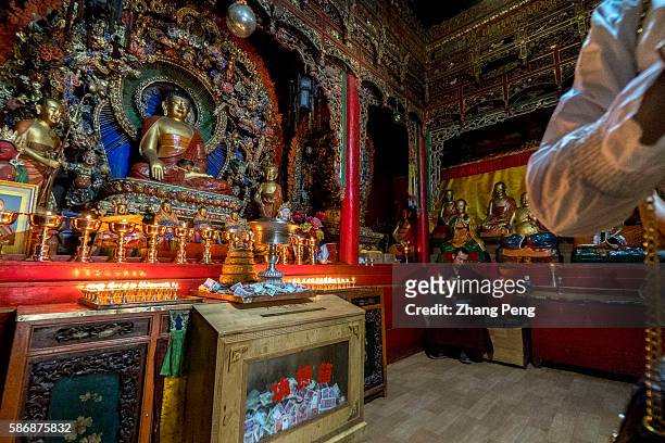 Buddha statue and butter lamps. Kumbum Monastery is one of the two most important Tibetan Buddhist monasteries outside Tibet. In order to commemorate...