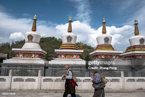 Believers from Tibetan pray around the Eight Propitious Stupas, which represent the eight stages of Buddha's life. Kumbum Monastery is one of the two...